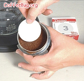 最后将丸型滤纸放在咖啡粉中央表面
